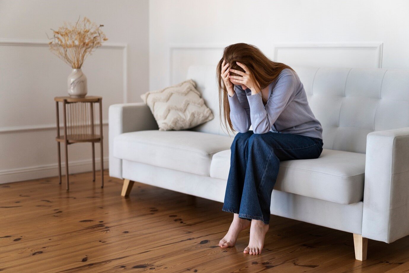 full-shot-anxious-woman-sitting-couch_23-2149450367